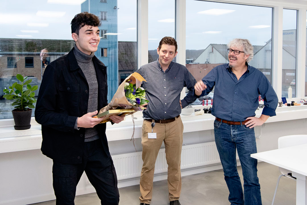 IBA Nexttech logovinder, Lorenze står med pris og blomster i hånden. Anders og Morten står ved siden af Lorenzo